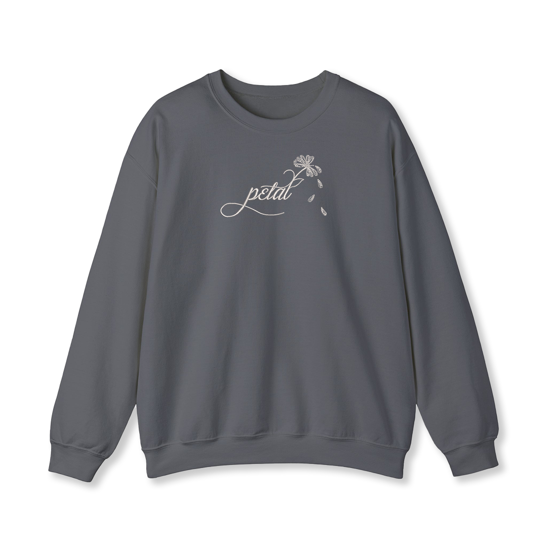 Dark grey sweatshirt with white embroidered “petal” script and daisy stem with falling petals on chest