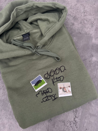 good kid maad city embroidery on a military green sweatshirt, with two album covers for kendrick Lamars album also stitched out and the title also