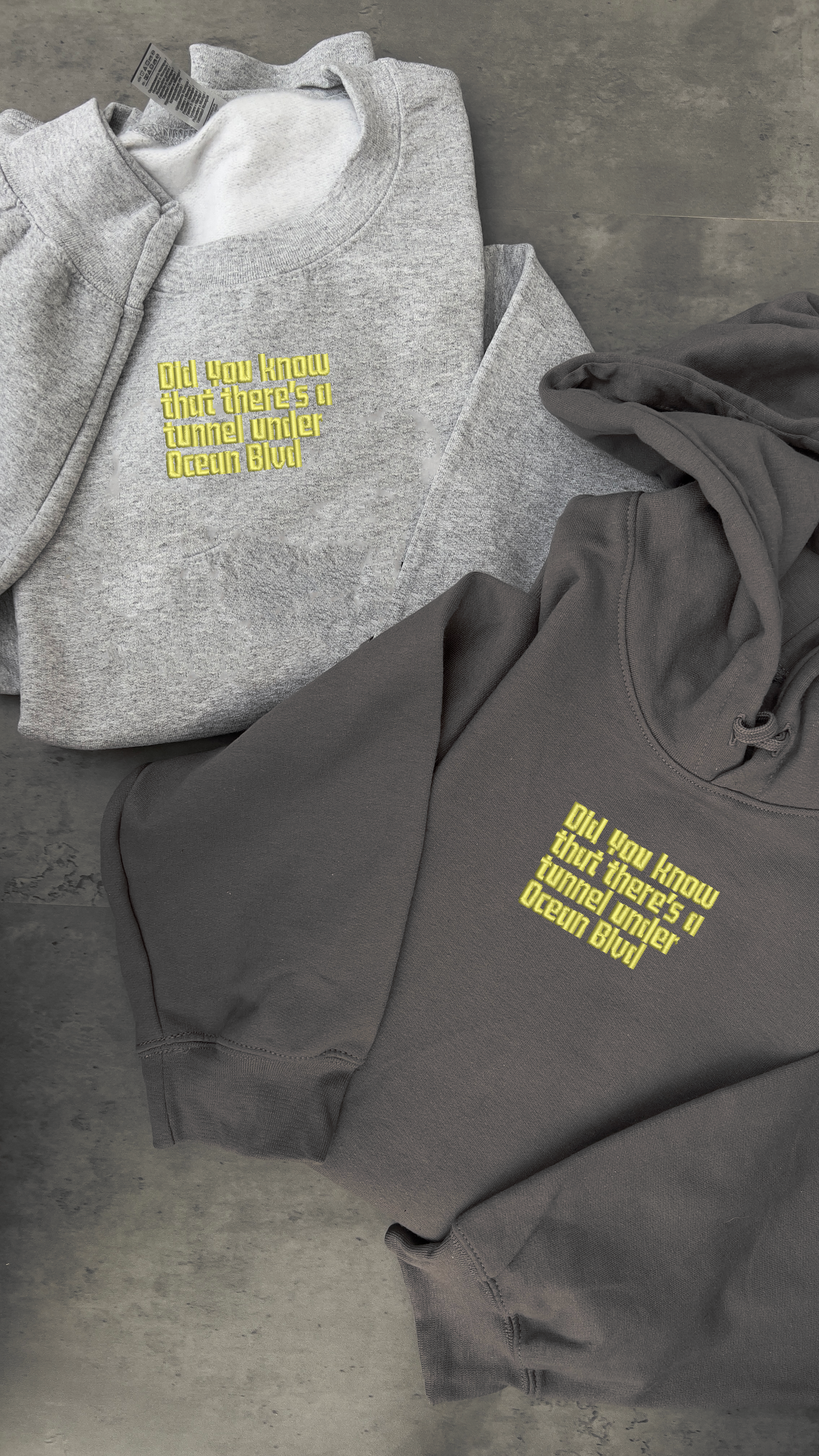 lana del rey embroidered sweatshirts, one of which is a light grey coloured that has 'did you know that there's a tunnel under ocean blvd' embroidered in a pale yellow as shown on the album cover, whilst the same embroidery is present on a different variation, a dark grey sweatshirt