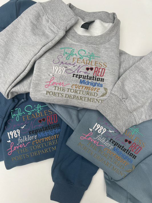 Taylor Swifts albums all embroidered onto a sweatshit using their individual colours and fonts specific to their album covers 