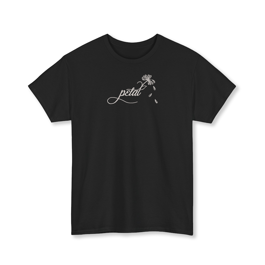 Black t-shirt featuring white embroidered cursive “petal” design with daisy stem and scattered petals