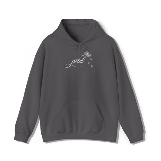 Dark grey hoodie with white embroidered “petal” script design flowing into a daisy stem with falling petals on the chest